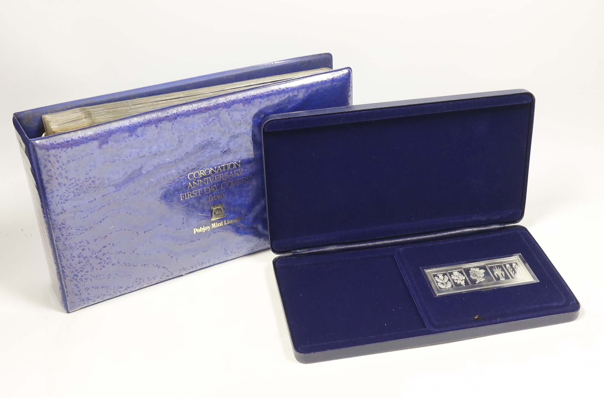 A cased Danbury Mint Queen Elizabeth II Silver Jubilee silver ingot and a Pobjoy Mint 25th anniversary of the Queen's coronation twin silver gilt medallions and First Day covers album
